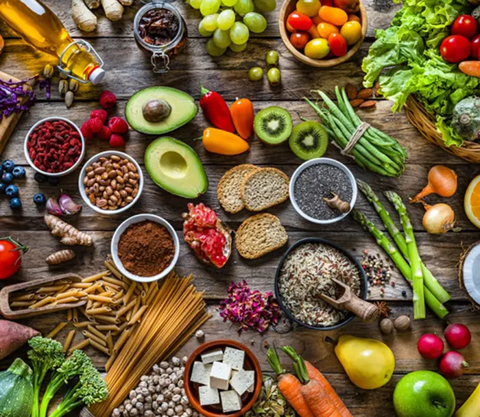 Table full of fresh vegetables, fruits, nuts and grains